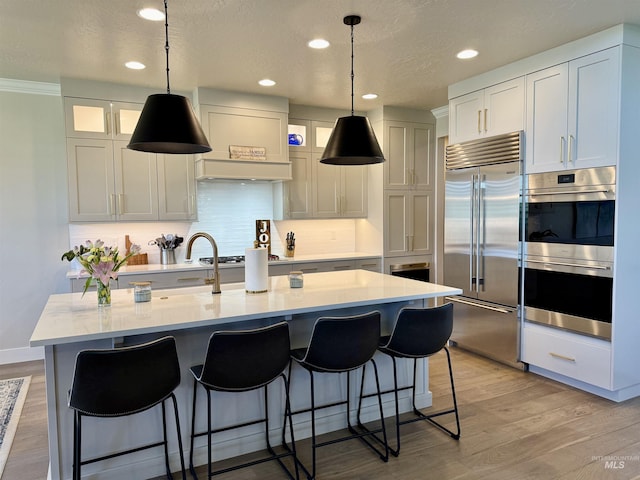 2280 N Burnam Ave, Star, ID 83669 - kitchen featuring stainless steel appliances, light countertops, recessed lighting, decorative backsplash, and light wood finished floors