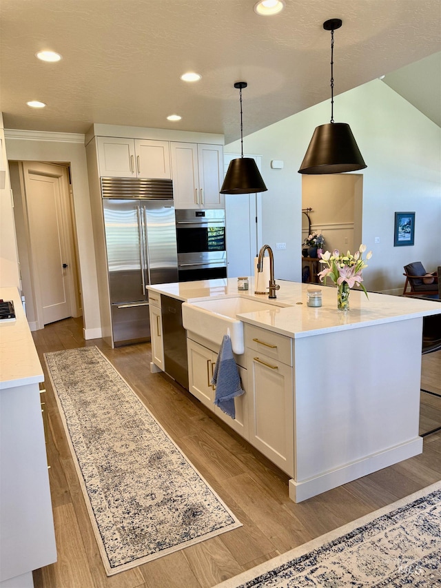 2280 N Burnam Ave, Star, ID 83669 - kitchen with a sink, appliances with stainless steel finishes, wood finished floors, white cabinets, and recessed lighting