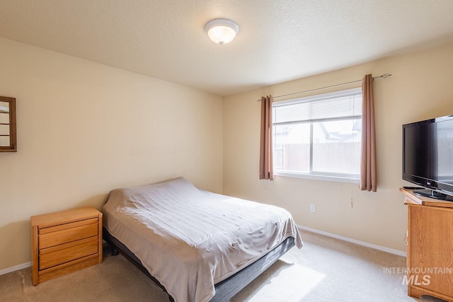 bedroom featuring baseboards and light colored carpet