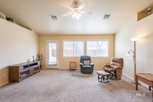 living area featuring a textured ceiling, visible vents, and carpet flooring