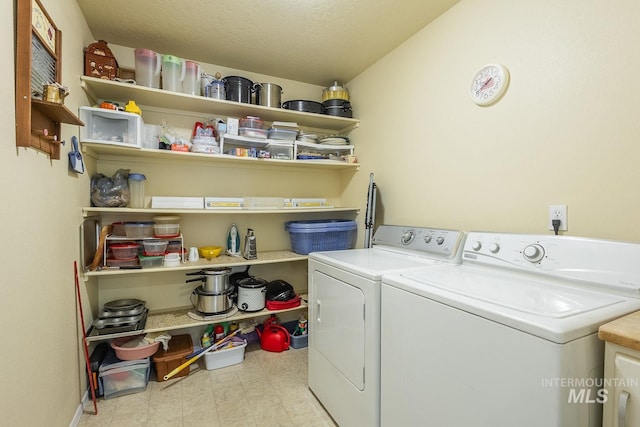 laundry area featuring laundry area, washing machine and dryer, a textured ceiling, and tile patterned floors