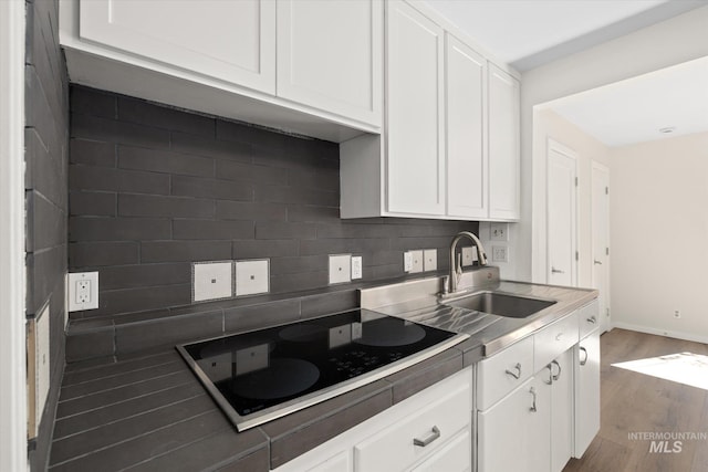 1806 N 28th St, Boise, ID 83703 - kitchen featuring black electric cooktop, a sink, wood finished floors, and white cabinets