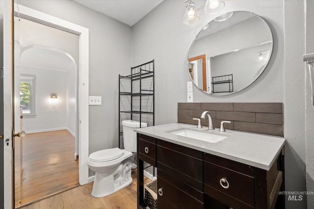 1806 N 28th St, Boise, ID 83703 - bathroom with wood finished floors, decorative backsplash, toilet, vanity, and baseboards