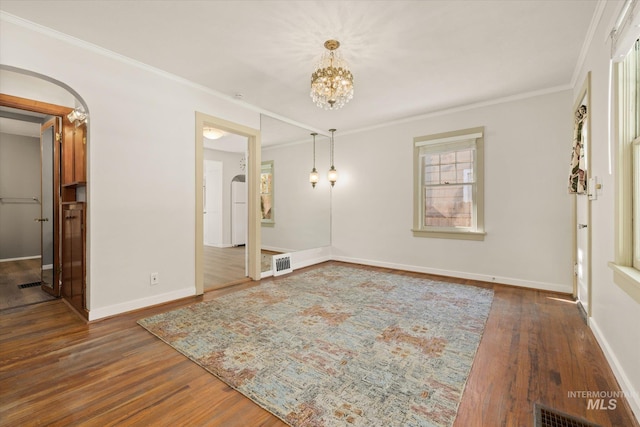 1806 N 28th St, Boise, ID 83703 - spare room featuring wood finished floors, a chandelier, crown molding, baseboards, and arched walkways