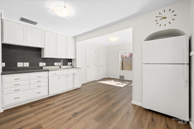 1806 N 28th St, Boise, ID 83703 - kitchen featuring freestanding refrigerator, backsplash, white cabinets, dark wood-style floors, and a sink