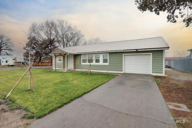 ranch-style home featuring a garage and a lawn