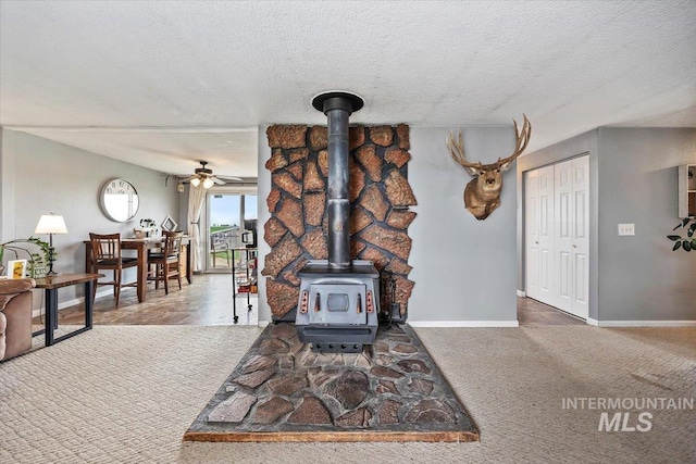 1910 E 3950 N, Filer, ID 83328 - carpeted living room featuring a wood stove, a ceiling fan, and a textured ceiling