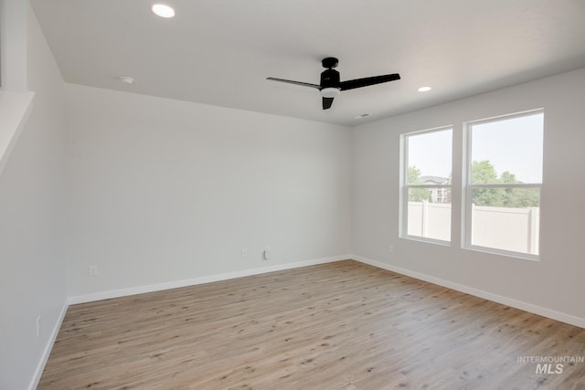 spare room featuring light wood-type flooring, ceiling fan, baseboards, and recessed lighting