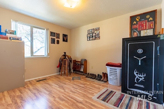 miscellaneous room with visible vents, baseboards, a textured ceiling, and wood finished floors