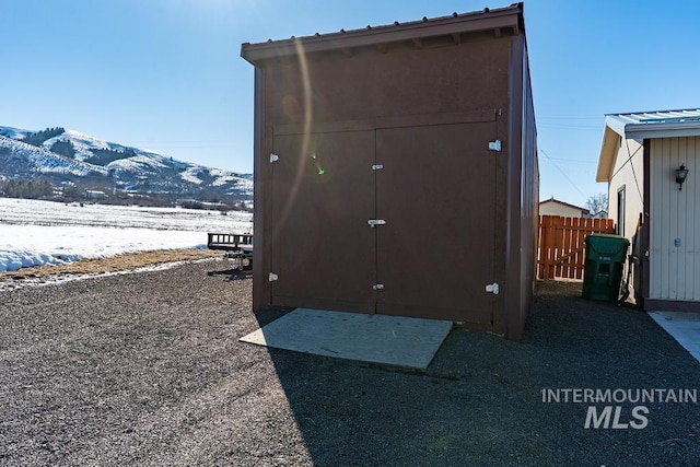 view of shed featuring fence and a mountain view