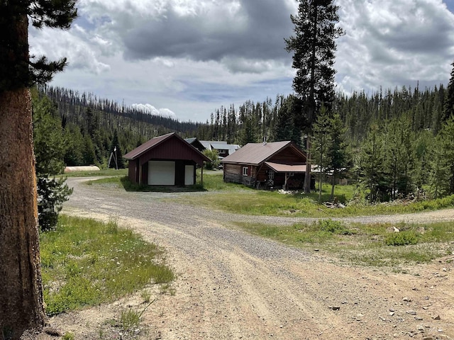 2771 Dixie Rd, Dixie, ID 83525 - view of front of home featuring a view of trees, a garage, dirt driveway, an outbuilding, and a metal roof