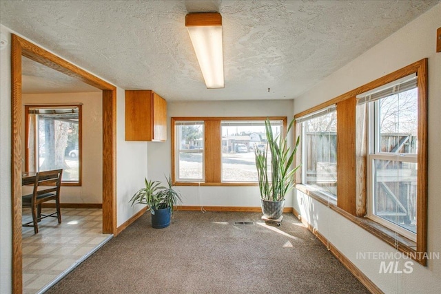 interior space with visible vents, baseboards, and a textured ceiling