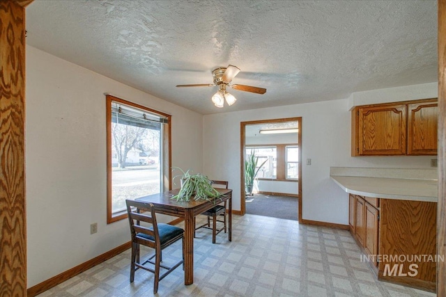 dining area with light floors, baseboards, and ceiling fan