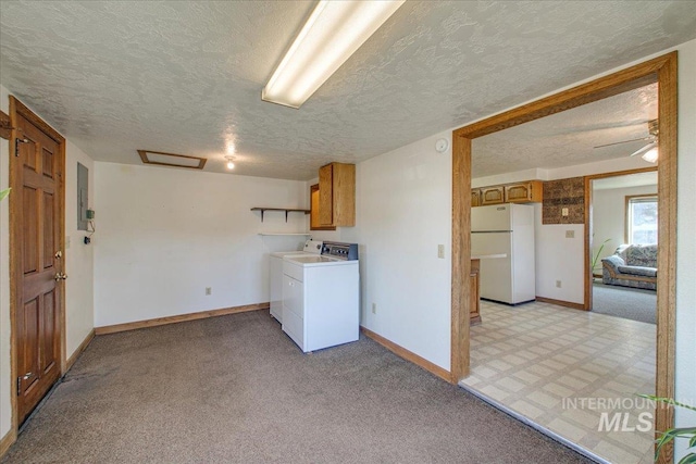 washroom with washing machine and dryer, cabinet space, baseboards, and light carpet