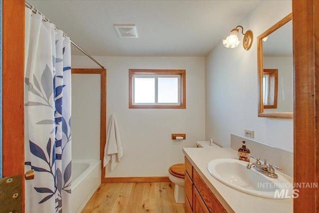 bathroom with visible vents, baseboards, toilet, wood finished floors, and vanity