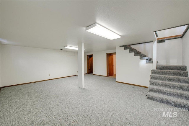 finished below grade area with stairway, baseboards, carpet, and visible vents