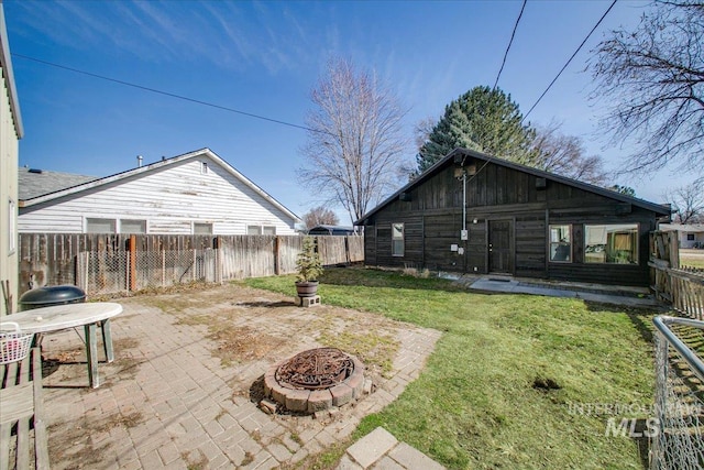 view of yard with a patio area, a fire pit, and a fenced backyard