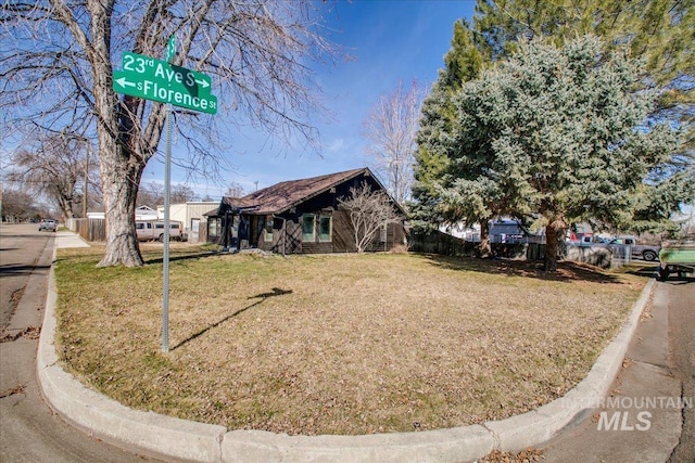 view of front of home featuring a front lawn and fence