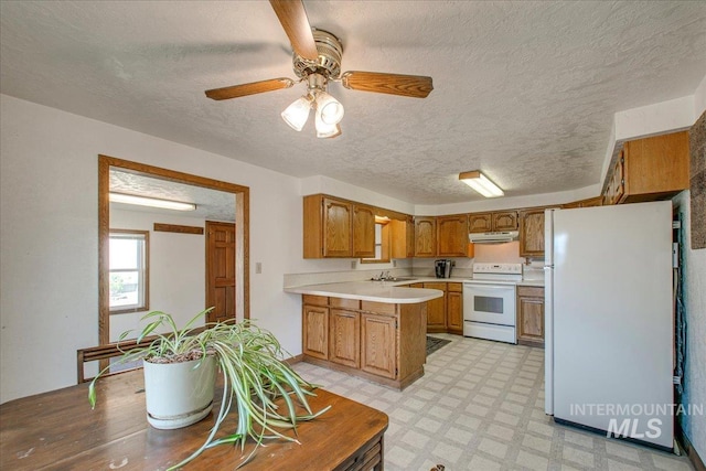 kitchen featuring white appliances, brown cabinetry, light floors, a peninsula, and light countertops