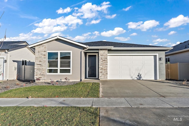 ranch-style house featuring concrete driveway, fence, a garage, and a front lawn