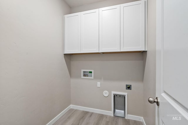 laundry area with electric dryer hookup, washer hookup, cabinet space, light wood-style floors, and baseboards