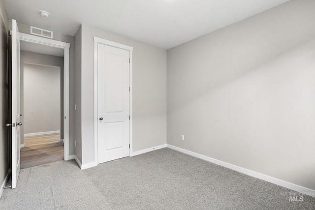 unfurnished bedroom with baseboards, visible vents, and carpet floors