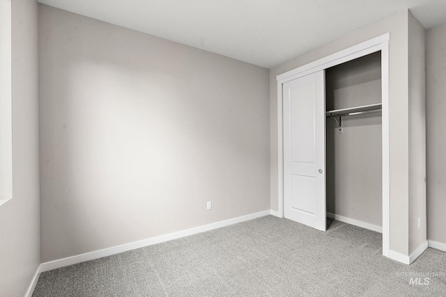 unfurnished bedroom featuring a closet, baseboards, and carpet floors