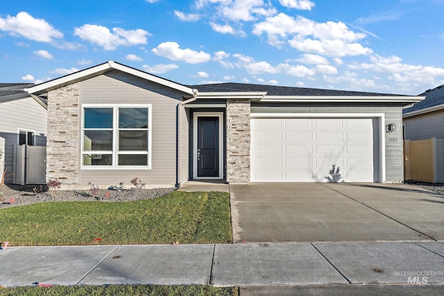 single story home with concrete driveway, a garage, and a front yard