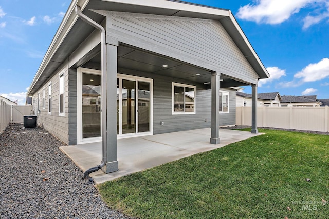 back of property featuring central AC unit, a patio area, a lawn, and a fenced backyard