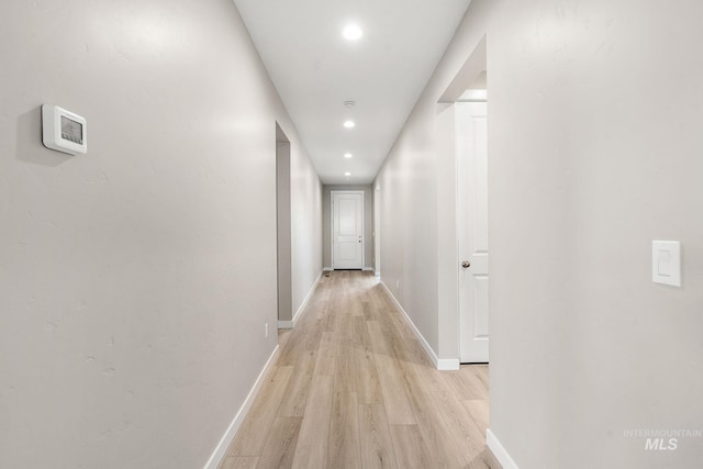 hallway featuring recessed lighting, baseboards, and light wood finished floors