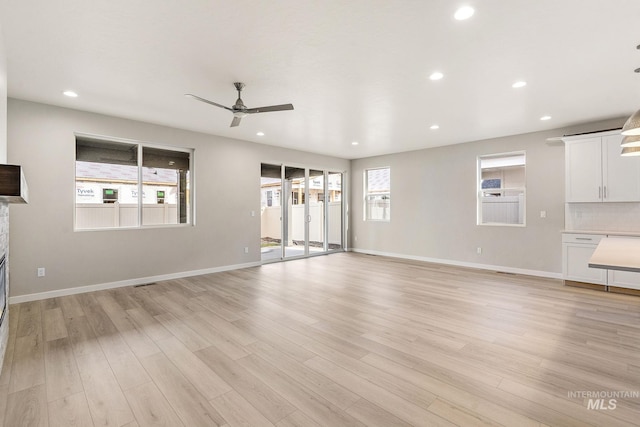 unfurnished living room featuring recessed lighting, light wood-style flooring, and baseboards