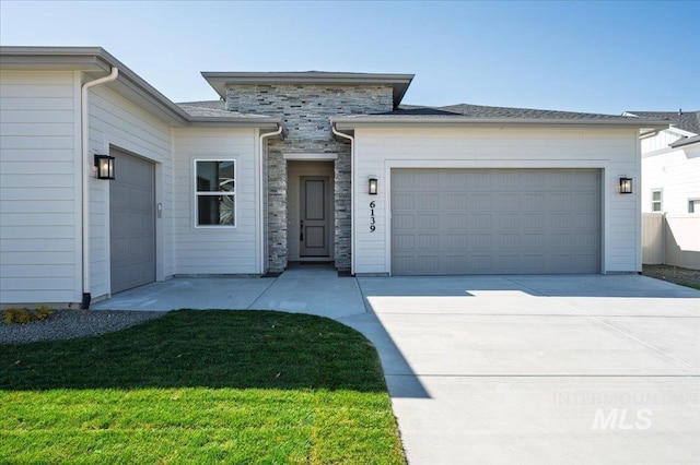 6139 W Burnt Sage Dr, Meridian, ID 83646 - view of front facade featuring an attached garage, concrete driveway, stone siding, and a front lawn