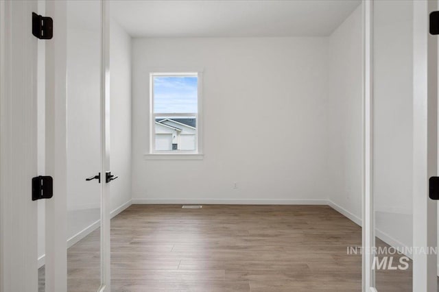 6139 W Burnt Sage Dr, Meridian, ID 83646 - unfurnished room featuring french doors, light wood finished floors, and baseboards