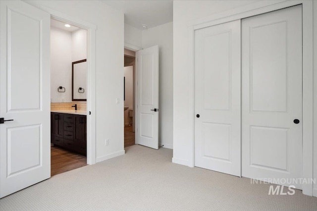 6139 W Burnt Sage Dr, Meridian, ID 83646 - unfurnished bedroom with a closet, baseboards, recessed lighting, ensuite bath, and light colored carpet