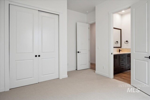 6139 W Burnt Sage Dr, Meridian, ID 83646 - unfurnished bedroom featuring a closet, baseboards, connected bathroom, and carpet