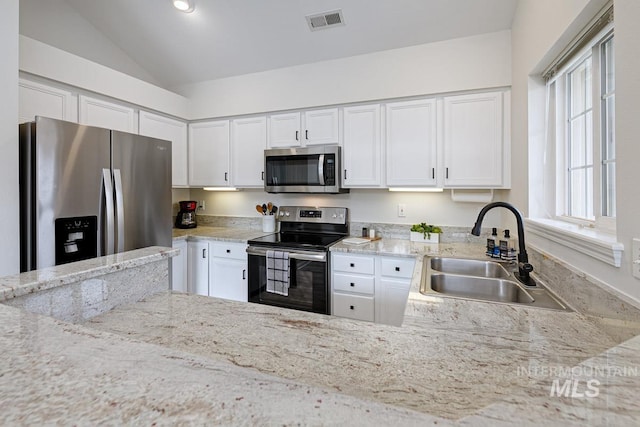 5158 S Surprise Way, Boise, ID 83716 - kitchen featuring stainless steel appliances, a sink, vaulted ceiling, white cabinets, and light stone countertops