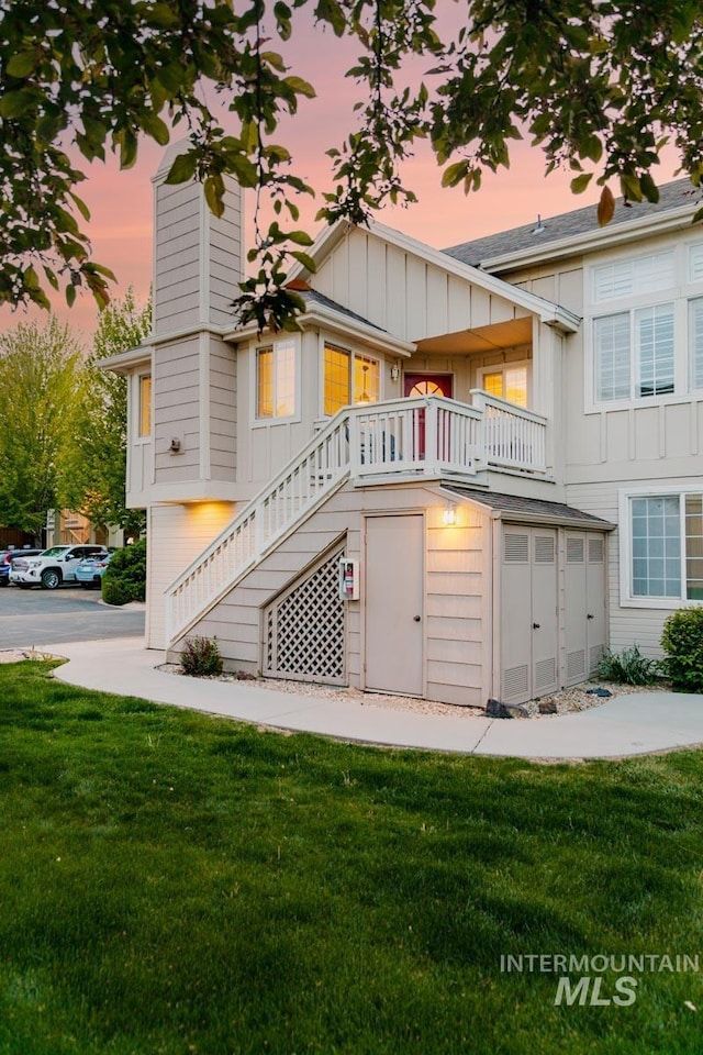 5158 S Surprise Way, Boise, ID 83716 - back of property at dusk with board and batten siding, stairs, a lawn, and a chimney