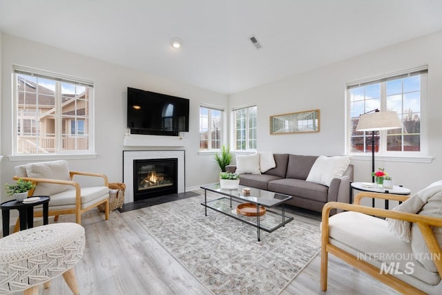 5158 S Surprise Way, Boise, ID 83716 - living area with plenty of natural light, wood finished floors, a fireplace with flush hearth, and baseboards