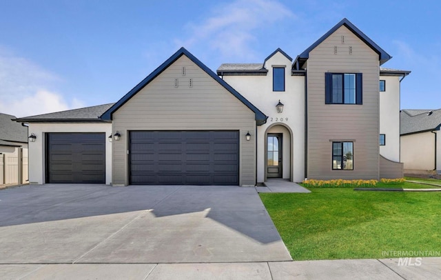 view of front of house featuring concrete driveway, an attached garage, and a front lawn