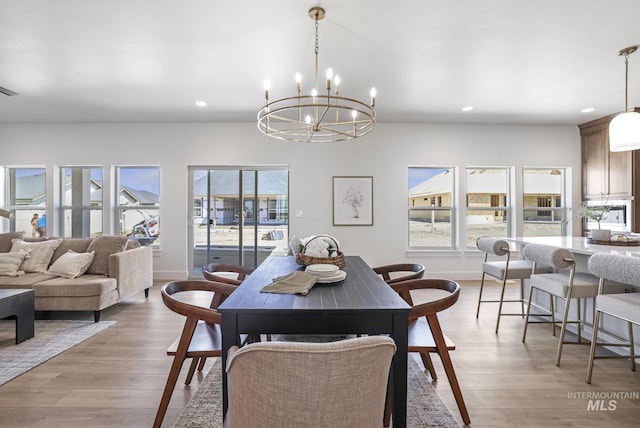 dining space with recessed lighting, light wood-style floors, baseboards, and a notable chandelier