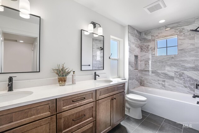 bathroom featuring visible vents, tile patterned floors, bathtub / shower combination, and a sink