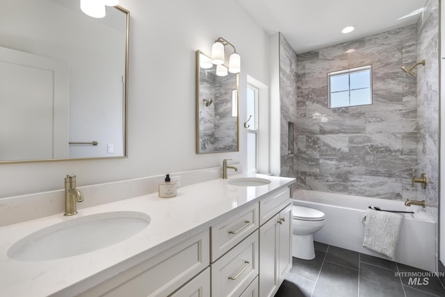 bathroom featuring toilet, shower / bathtub combination, a sink, and double vanity