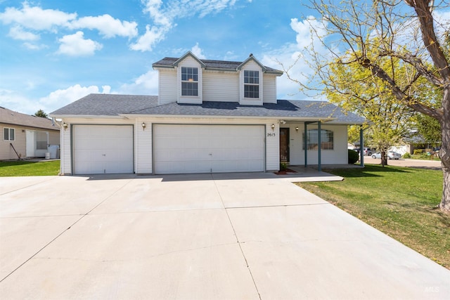 traditional home featuring concrete driveway, an attached garage, and a front lawn