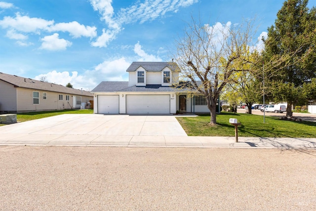 traditional-style house with concrete driveway, a front yard, and a garage