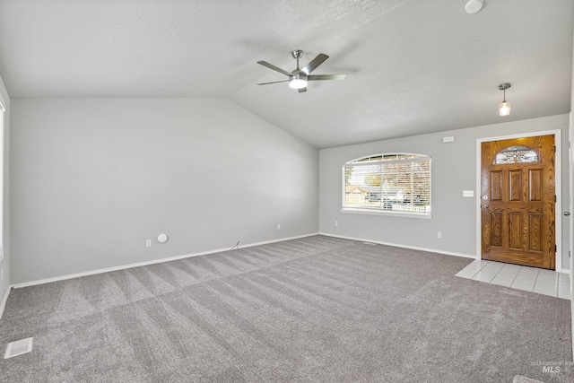 unfurnished living room featuring visible vents, a ceiling fan, carpet, a textured ceiling, and lofted ceiling