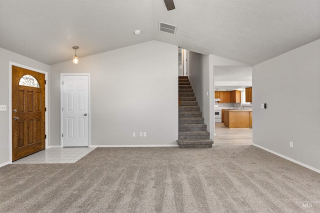 interior space featuring baseboards, a textured ceiling, stairway, light carpet, and lofted ceiling