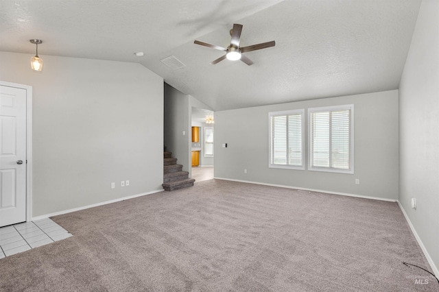 unfurnished living room with a ceiling fan, carpet flooring, vaulted ceiling, and stairs