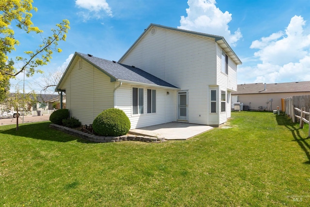 rear view of house featuring a yard, fence, and a patio