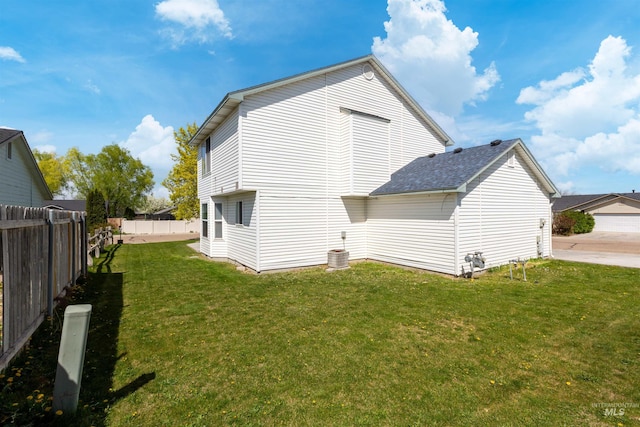 view of property exterior featuring cooling unit, a shingled roof, a yard, and a fenced backyard