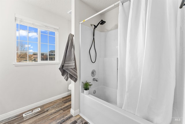 full bathroom featuring visible vents, toilet, shower / bath combo, wood finished floors, and baseboards